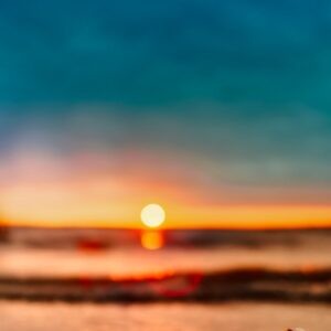 A stock image of a sun setting over waves.