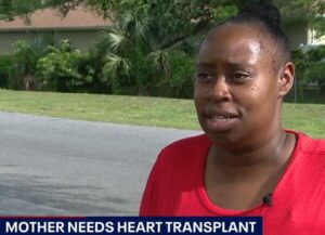 Heart transplant candidate Tashawna Shepard is interviewed by FOX Orlando. The headline reads Mother Needs Heart Transplant. Tashawna has brown skin, brown eyes, a bright red shirt, and black hair pulled up into a bun.