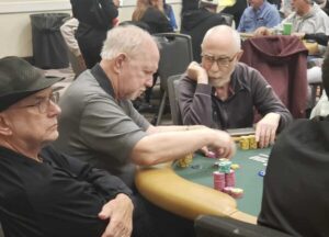 Three men at a poker table, all with white skin and white hair.