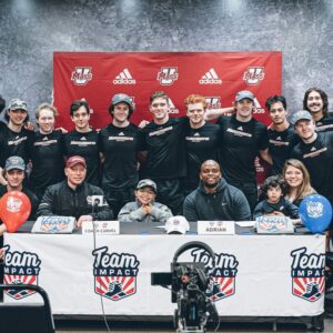 Dozens of UMass men's hockey program players with members of the Team IMPACT nonprofit, Coach Carvel, and 9-year-old Adrian Diaz.