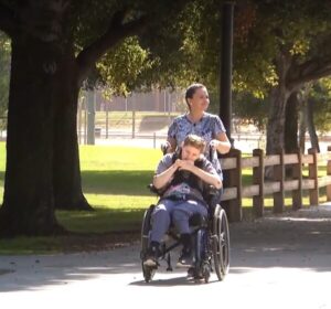 Tiffany pushes her sister Ashley Keen in her wheelchair in the park.