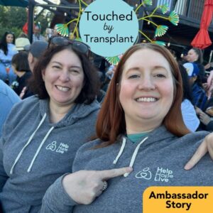 Transplant recipient Liz Barnett shows off her Help Hope Live hoodie with Jen Smilg from Help Hope Live at an outdoor event. Graphic reads Touched by Transplant Ambassador Story.