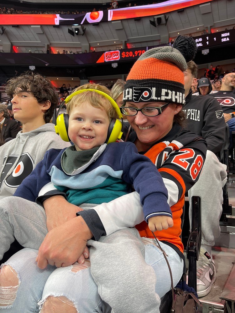 3-year-old Sidney Schmid is at a Philadelphia Flyers game with headphones on,