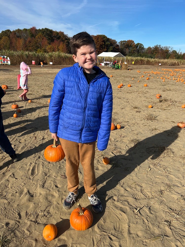 12-year-old Tommy Schrank holds a pumpkin at the pumpkin patch.