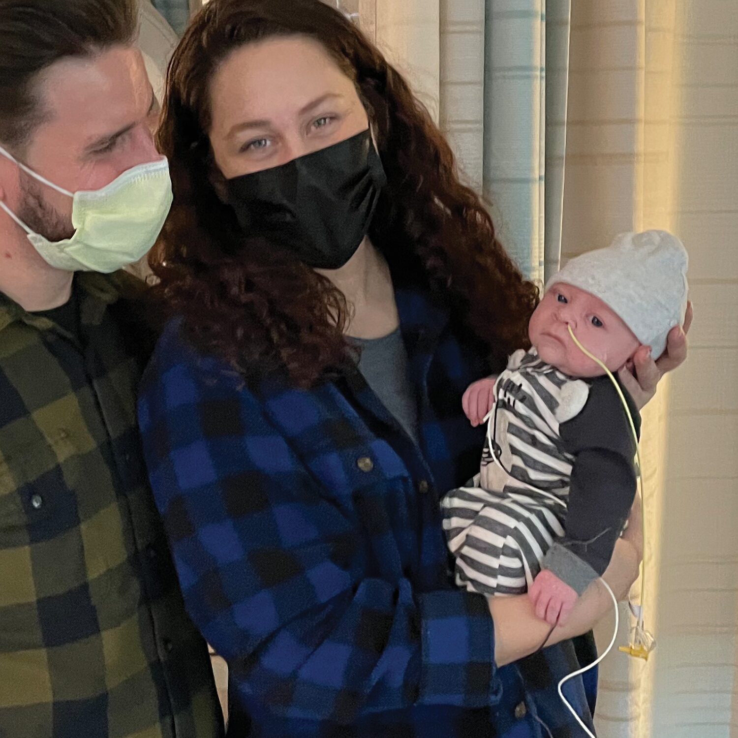 Mom and dad hold baby Sidney Schmid who is connected to a breathing tube.