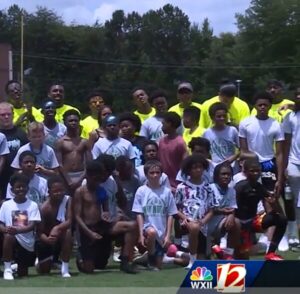 Kids and teens pose with KJ Henry and other football players at the 2nd annual Why Not Me camp in NC in 2025. From WXII 12.