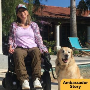 A photo of Cynthia Noonan seated in a power chair with her labrador service dog. The graphic reads Ambassador Story.