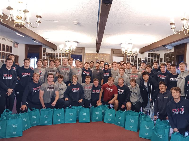 Penn Men's Lacrosse Team in December 2025 packing Bags of Hope for Help Hope Live.