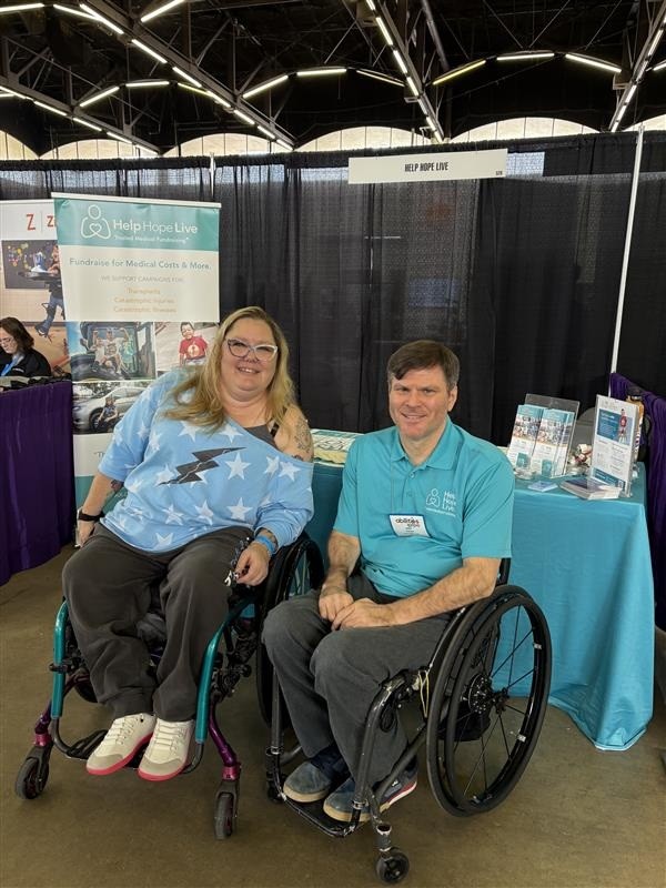 Help Hope Live client Jamie Carlson and staff member Andy Zimmer at Abilities Expo Dallas 2025, both seated in their wheelchairs.