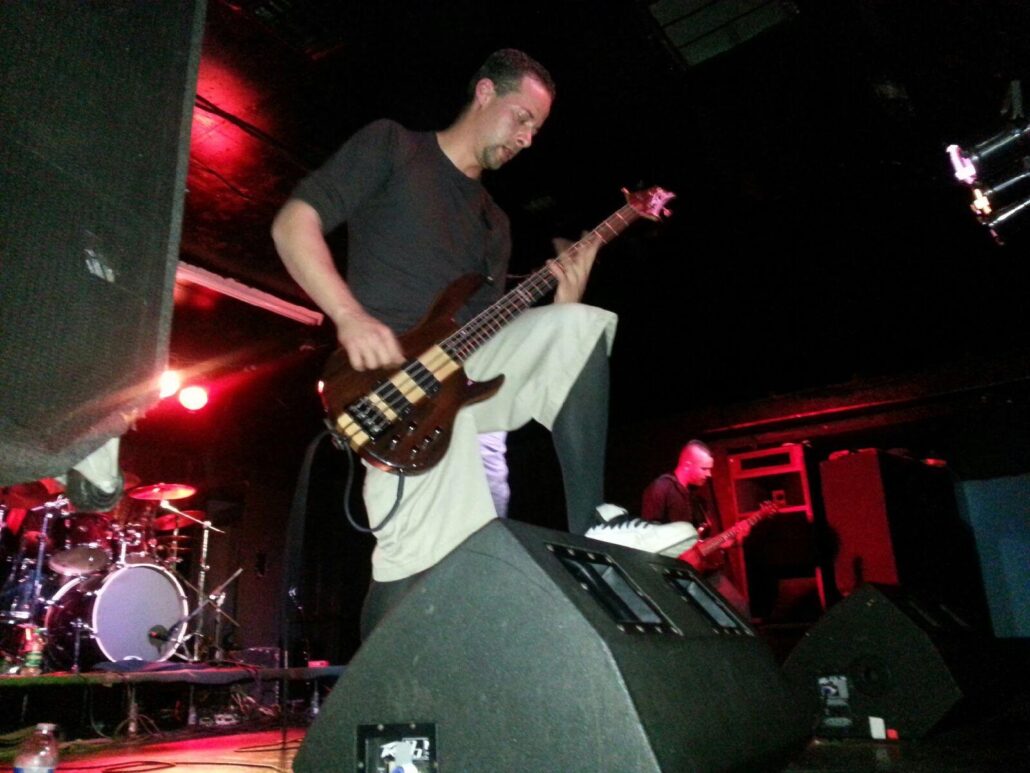 Pre-injury, Jason Ellefson plays bass on stage.
