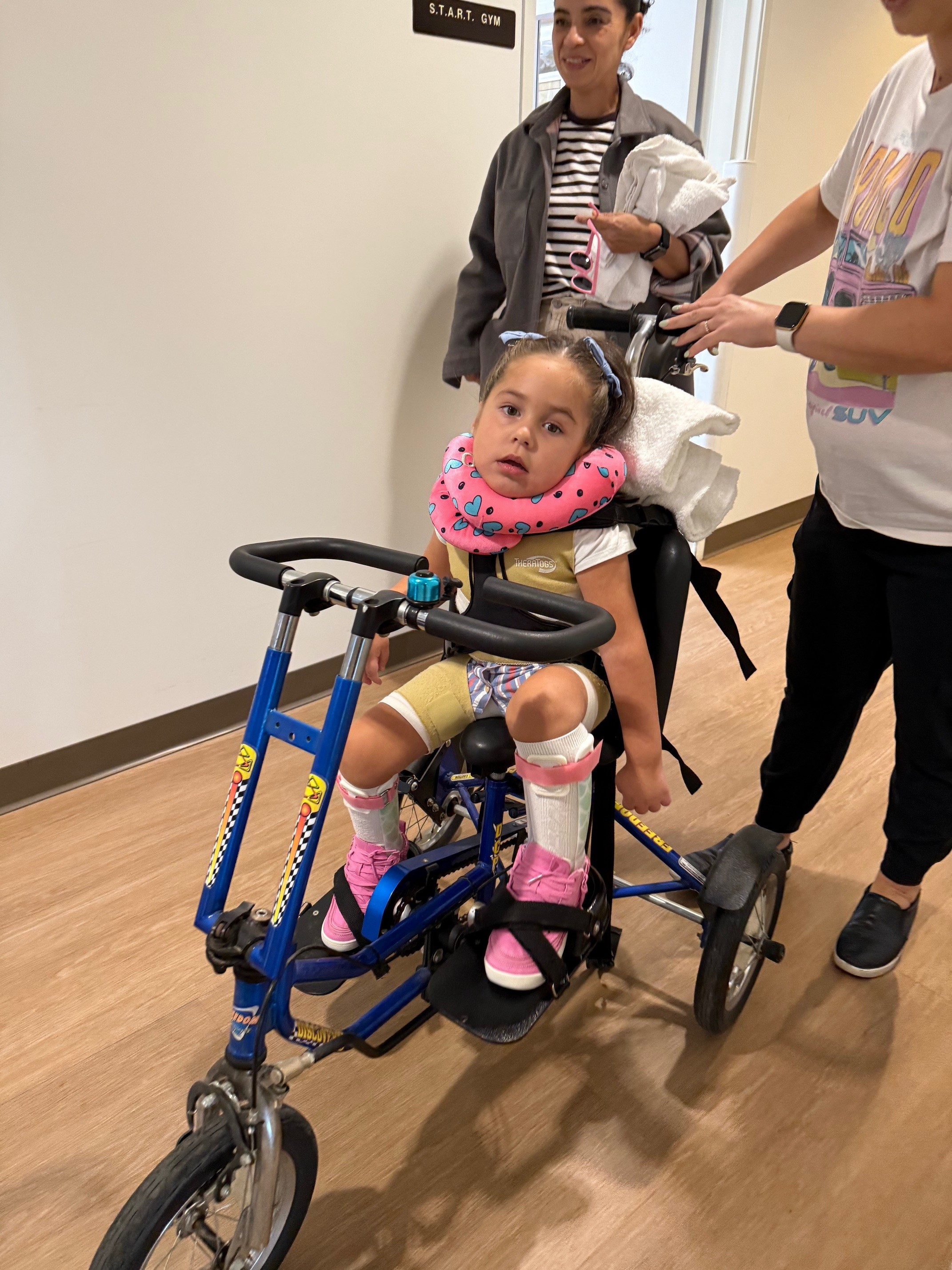 Brynlee Bonilla uses an adaptive bike in rehabilitation.