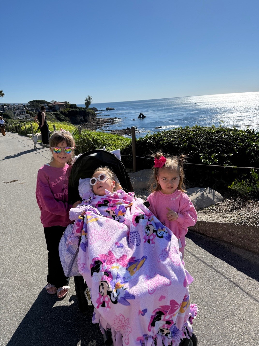 Brynlee Bonilla in a stroller visits the beach with her sisters.