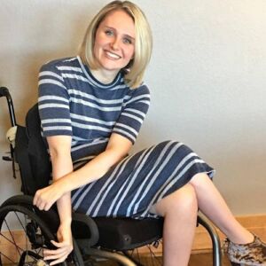 Lauren Shevchek is seated in her manual wheelchair with shoulder-length blonde hair.