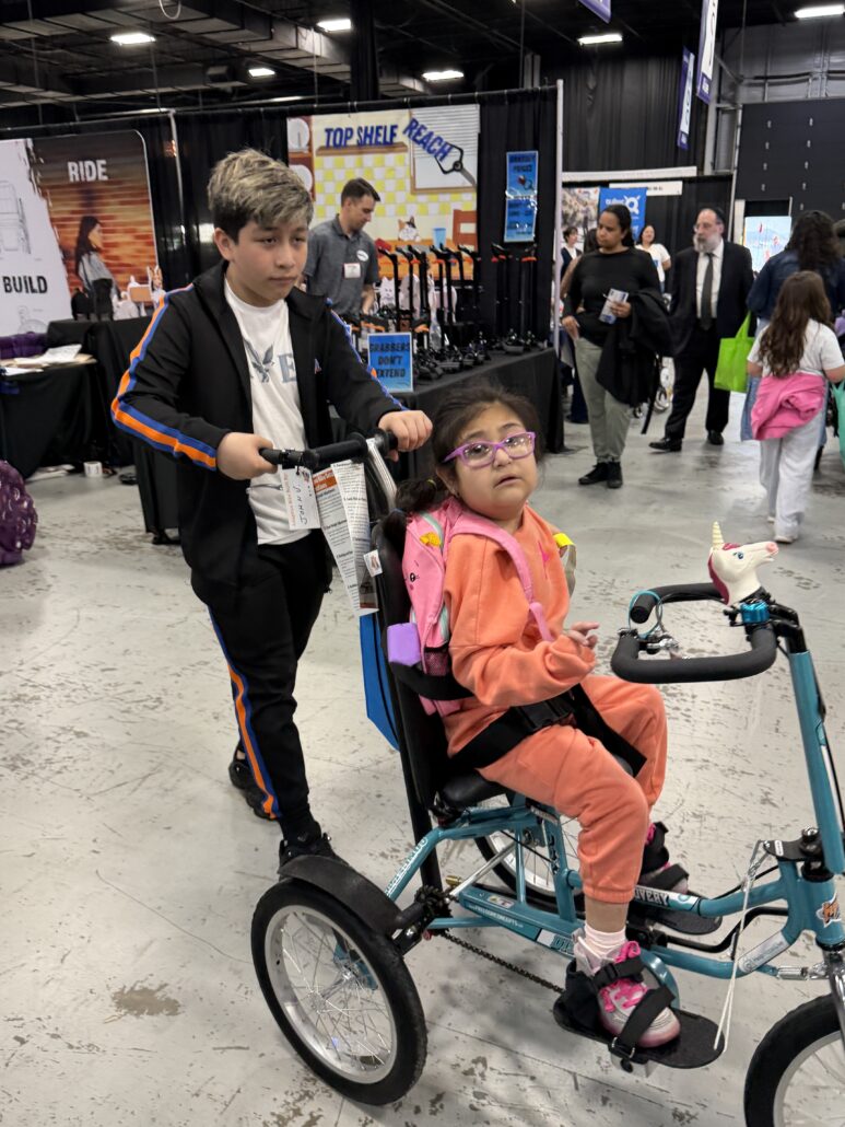Jeanney gets a push on her new adaptive bike at Abilities Expo NY 2026.