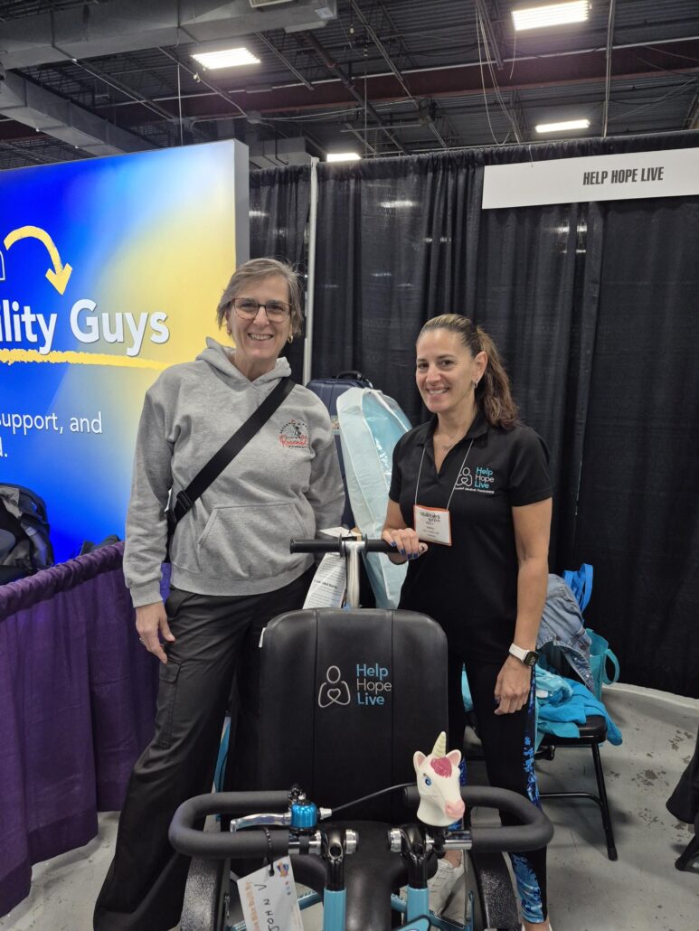 Denise Davis from the Rosenblatt Foundation with Kelly L Green and the Help Hope Live themed adaptive bike for Jeanney at Abilities Expo 2026.