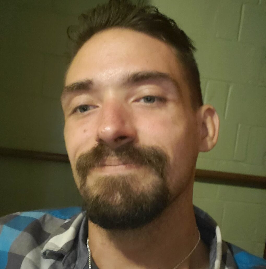 Selfie of Scott Hughes, who has light skin, blue-gray eyes, a brown goatee and mustache, and brown hair.