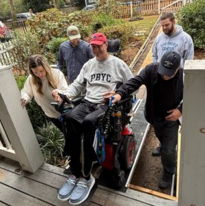 Sean Alazraki is helped up a new wheelchair ramp in his power chair.