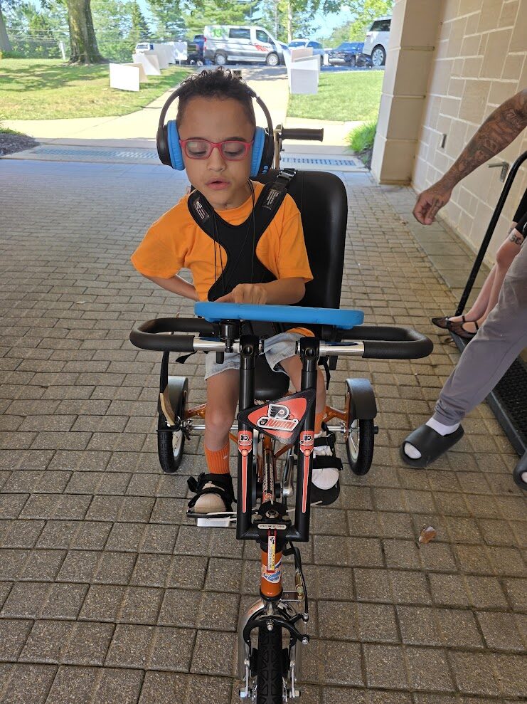 Angelo Murphy rides his new adaptive bike which has Flyers themed orange.