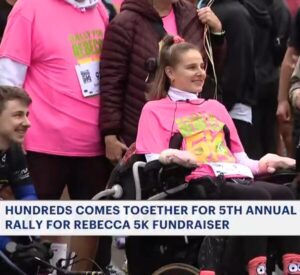 News 12 coverage of Rally for Rebecca Koltun 5K in 2026 with Rebecca seated in power chair.