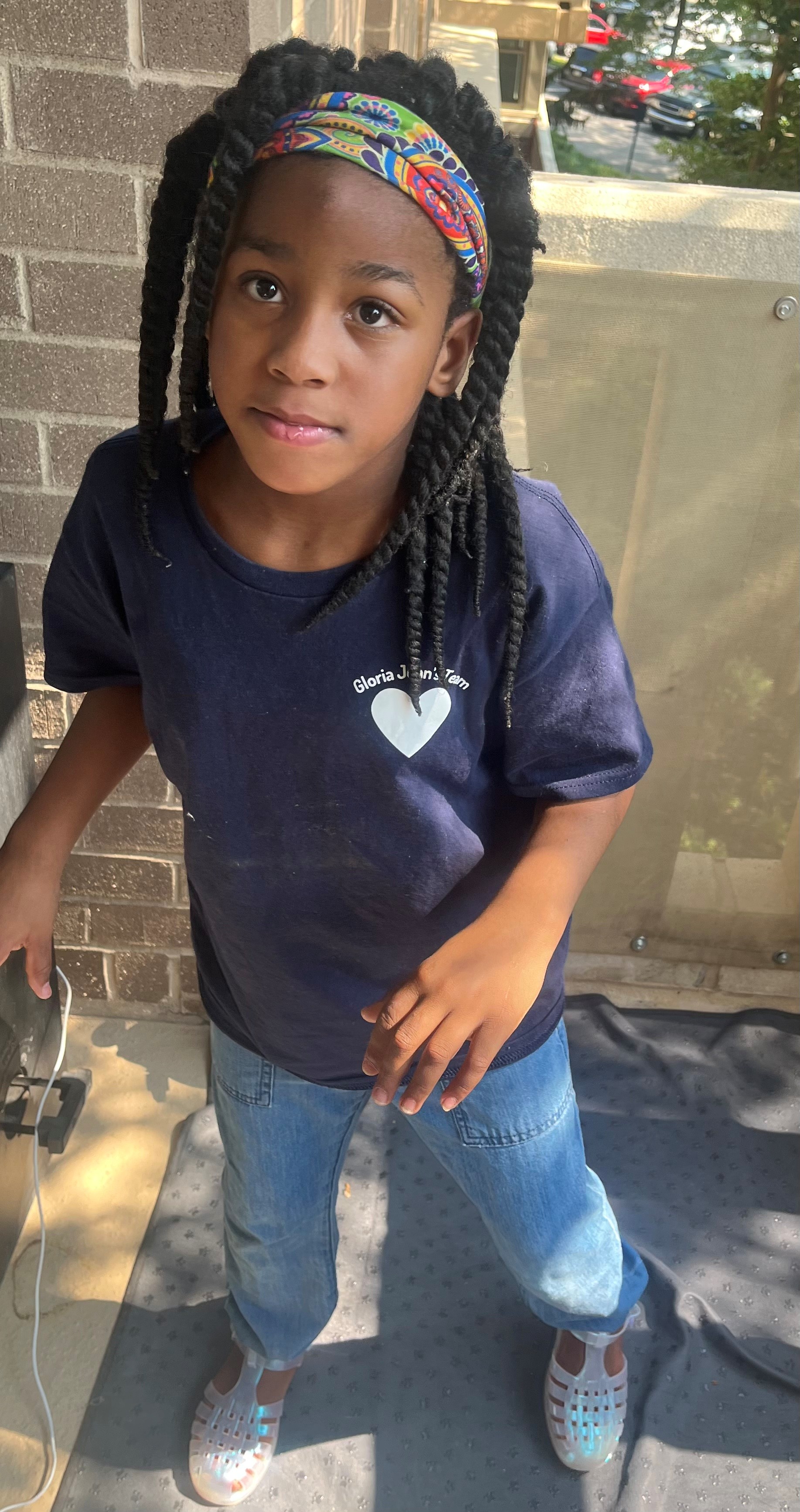 9-year-old Nya is Black with braided hair.