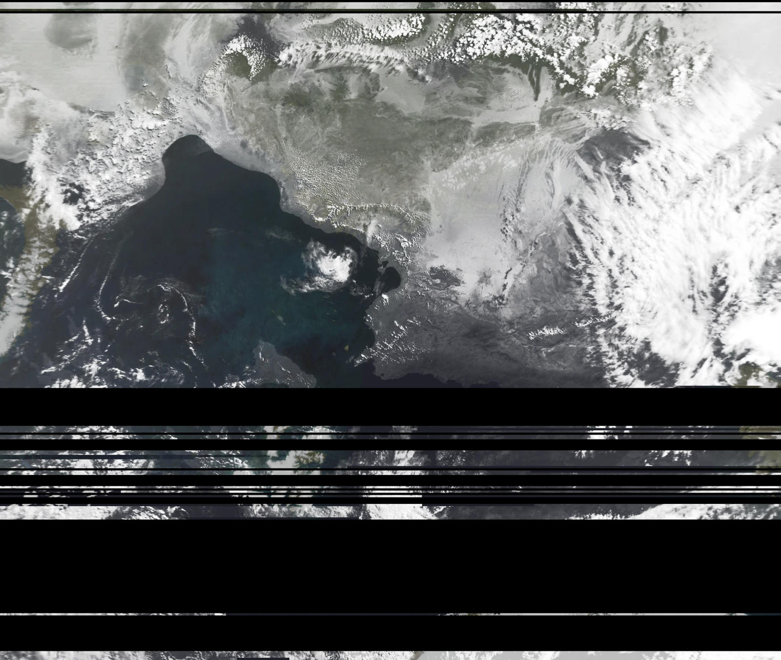 Passaggio satellitare in scala di grigi su una costa e un golfo scuro, con una banda di segnale perso nel terzo inferiore