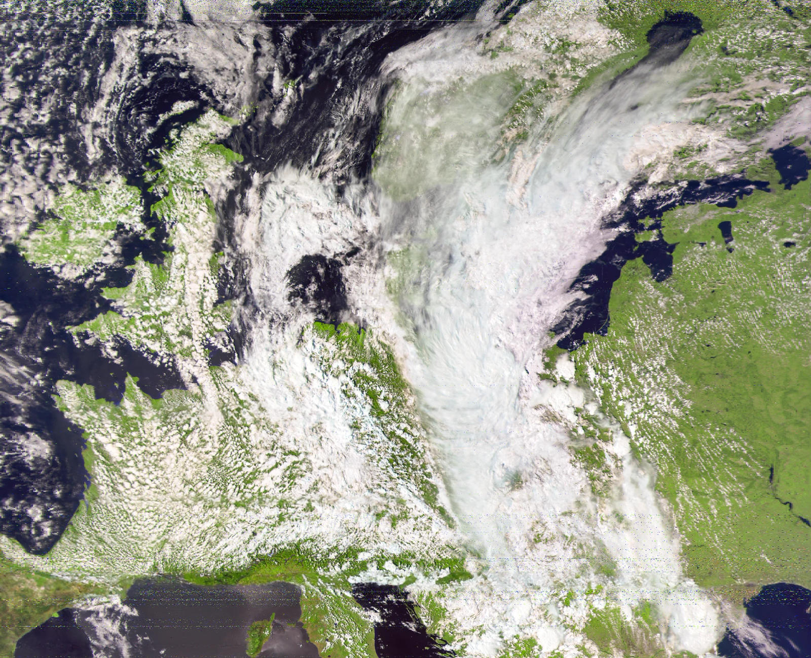Passaggio ampio su un fronte nuvoloso che attraversa terra verde e mare scuro