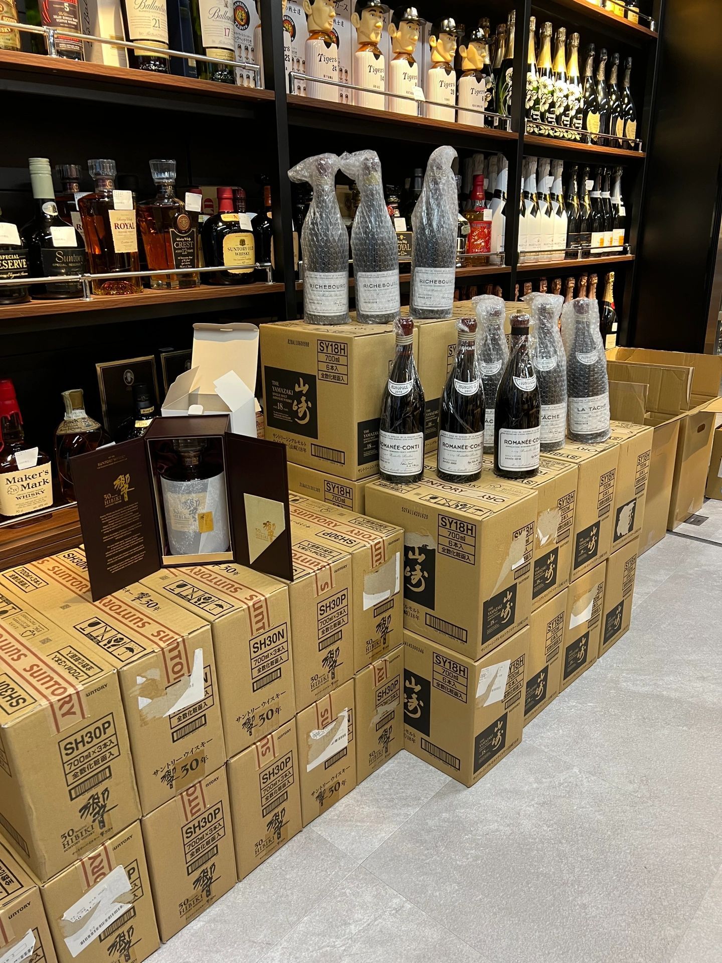 上門睇貨用放大鏡和燈光核對名酒封口水位防偽特徵