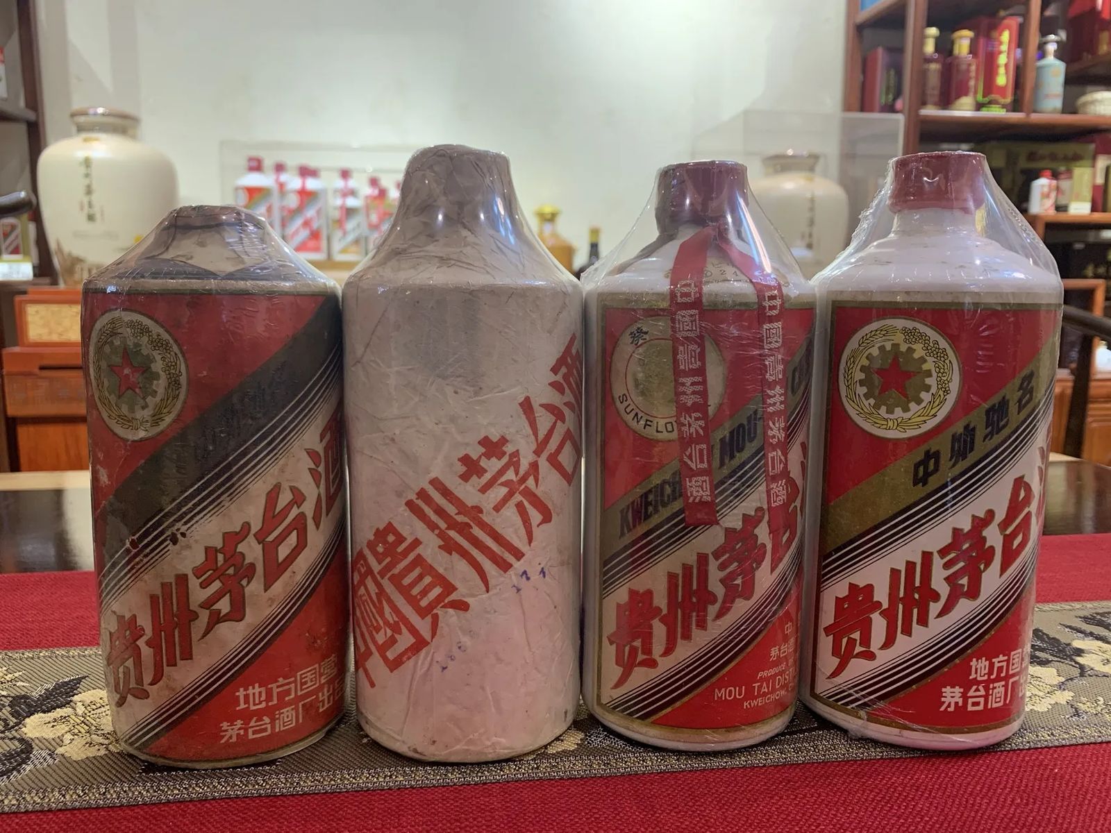 四支帶不同舊標籤和外加透明包膜的茅台酒瓶並列