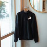 Hoodie - Unisex, svart, Alphas logga, en produkt från Nya Musik som utvecklar och engagerar människor i alla åldrar.