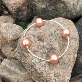 Välsignelsearmband - Pärlor - Persika - 12 mm, en produkt från Nya Musik som utvecklar och engagerar människor i alla åldrar.