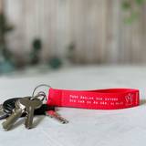 Nyckelring med tygband – Ängel, röd, en produkt från Nya Musik som utvecklar och engagerar människor i alla åldrar.