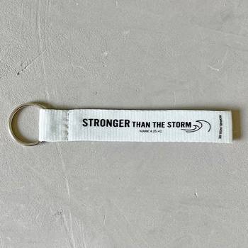 Nyckelring med tygband – Stronger, vit, en produkt från Nya Musik som utvecklar och engagerar människor i alla åldrar.