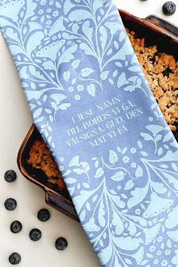 Kökshandduk - I Jesu namn till bords vi gå, en produkt från Nya Musik som utvecklar och engagerar människor i alla åldrar.