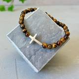 Armband – Kors - brun, en produkt från Nya Musik som utvecklar och engagerar människor i alla åldrar.