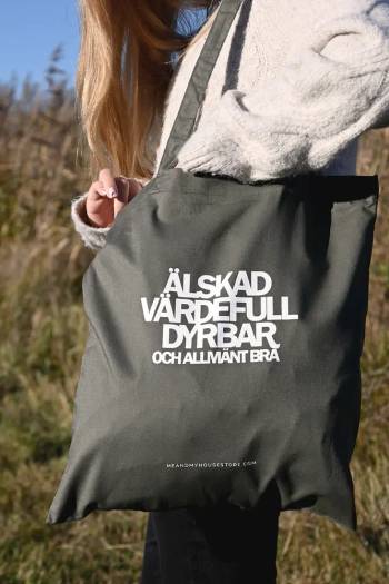 Tygkasse i olivgrönt: Älskad, värdefull, dyrbar, en produkt från Nya Musik som utvecklar och engagerar människor i alla åldrar.