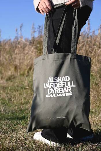 Tygkasse i olivgrönt: Älskad, värdefull, dyrbar, en produkt från Nya Musik som utvecklar och engagerar människor i alla åldrar.