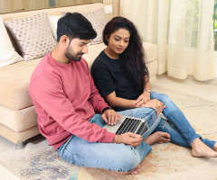 Couple shortlisting properties together on a laptop