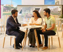 Property expert guiding a couple through project brochures