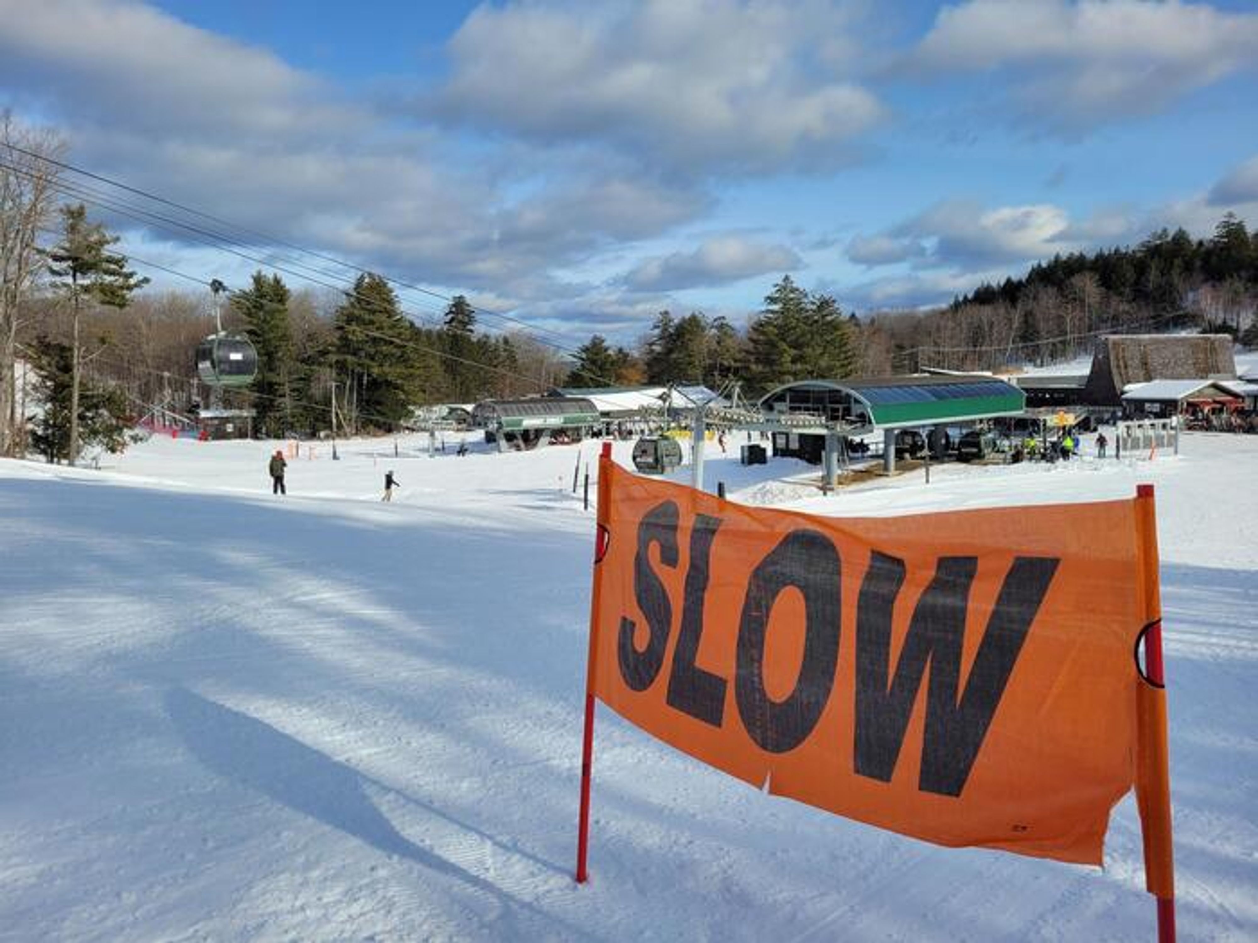 Skiiers skiing down towards base.