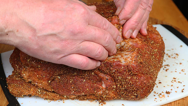 hands with dry rub on pork 