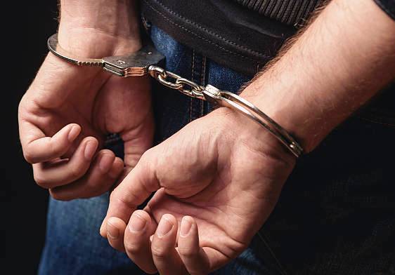 Close up of male hands in bracelets behind back