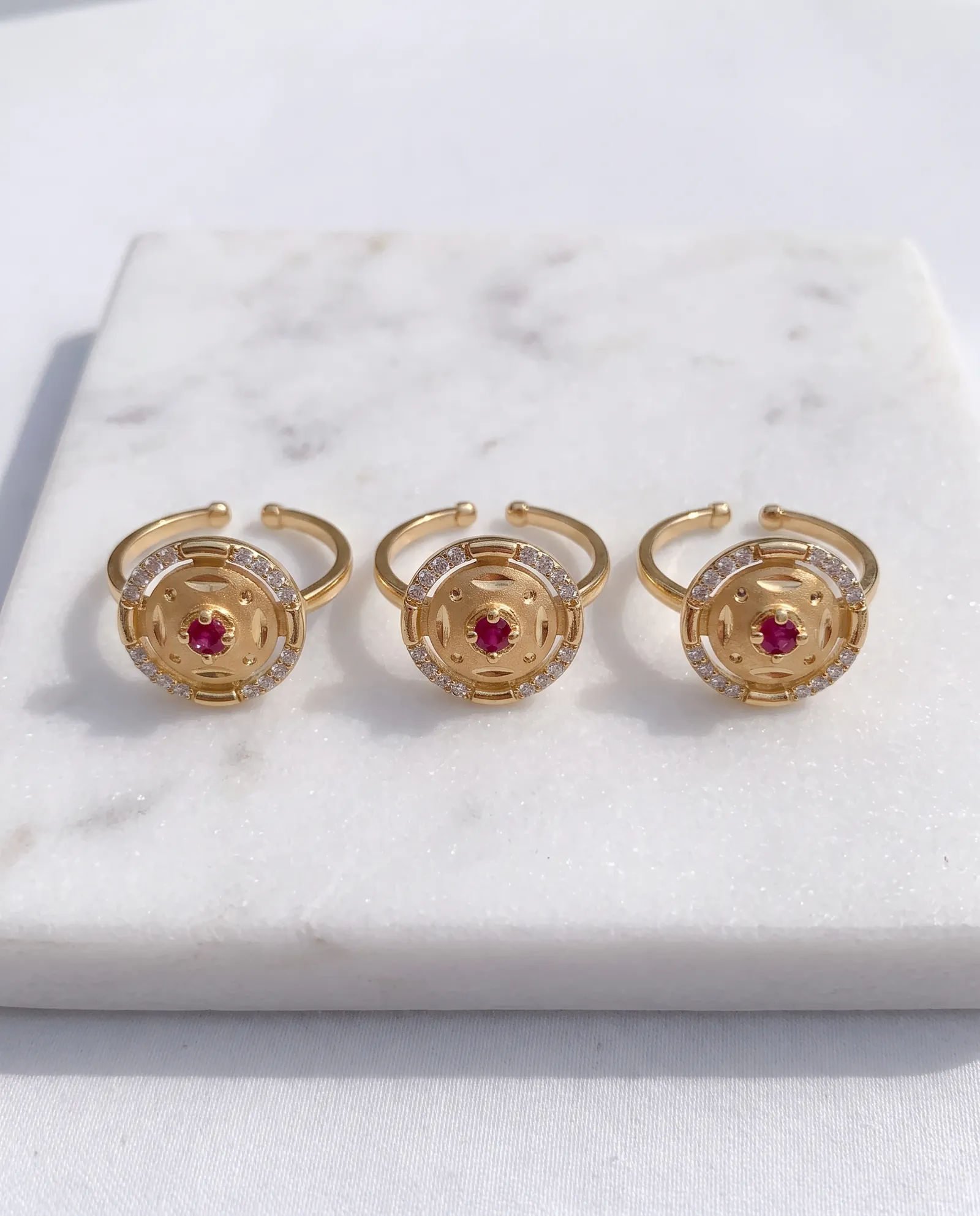 Circular Red AD Stone Ring laid on white marble