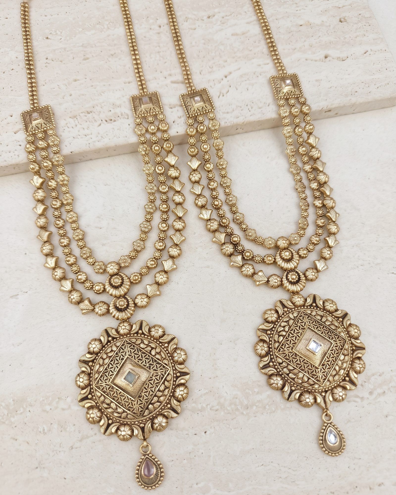 Antique Gold-Tone Medallion Layered Necklace laid on white marble