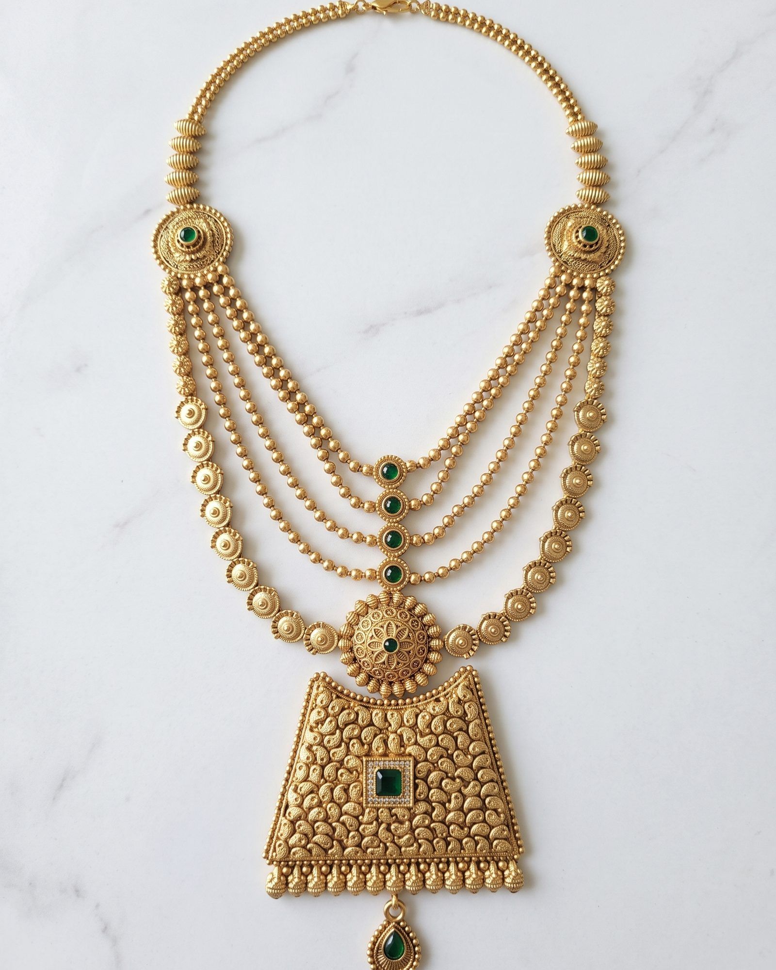 Antique Green Stone Layered Long Necklace laid on white marble