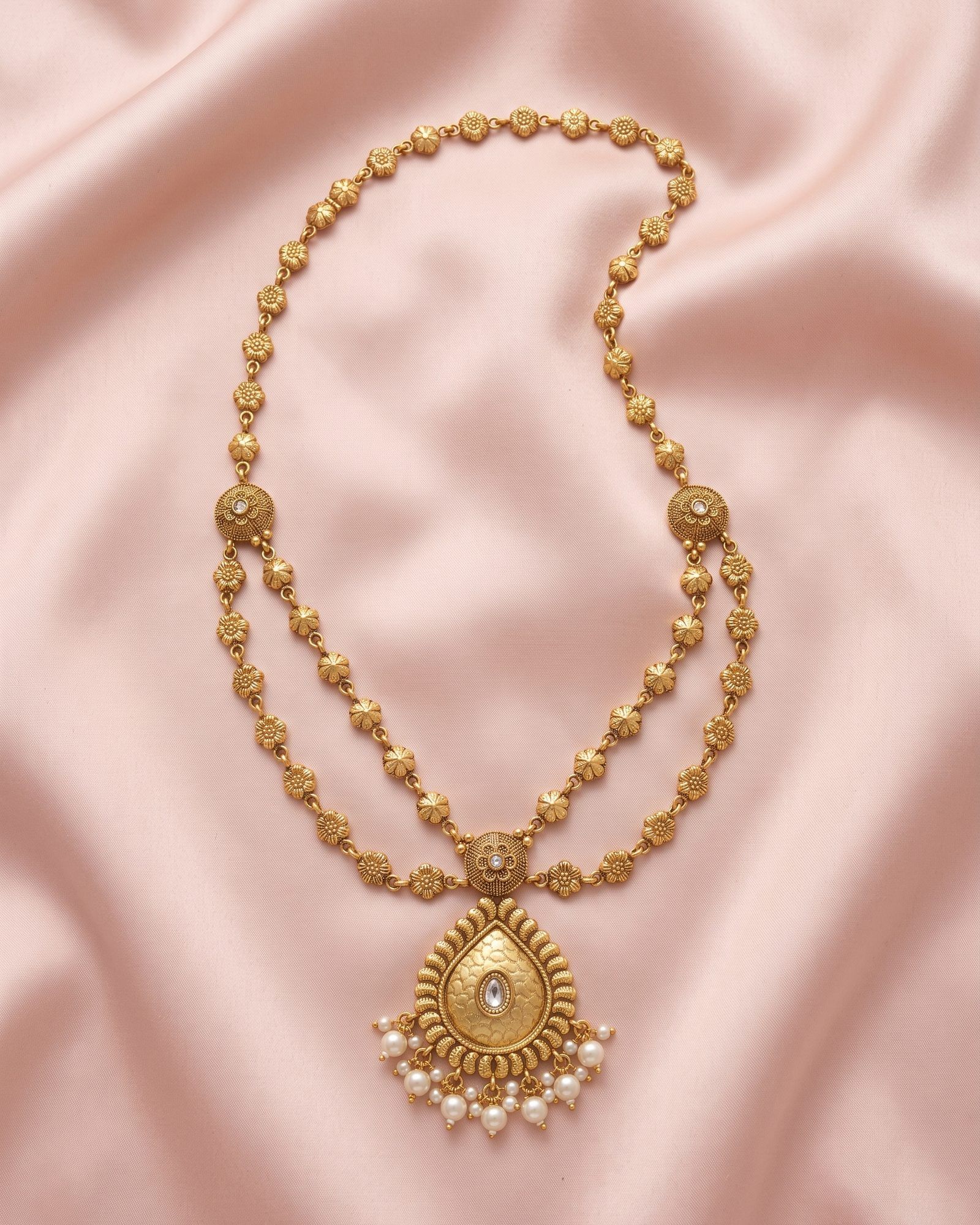 Antique Floral Teardrop Layered Necklace laid on white marble