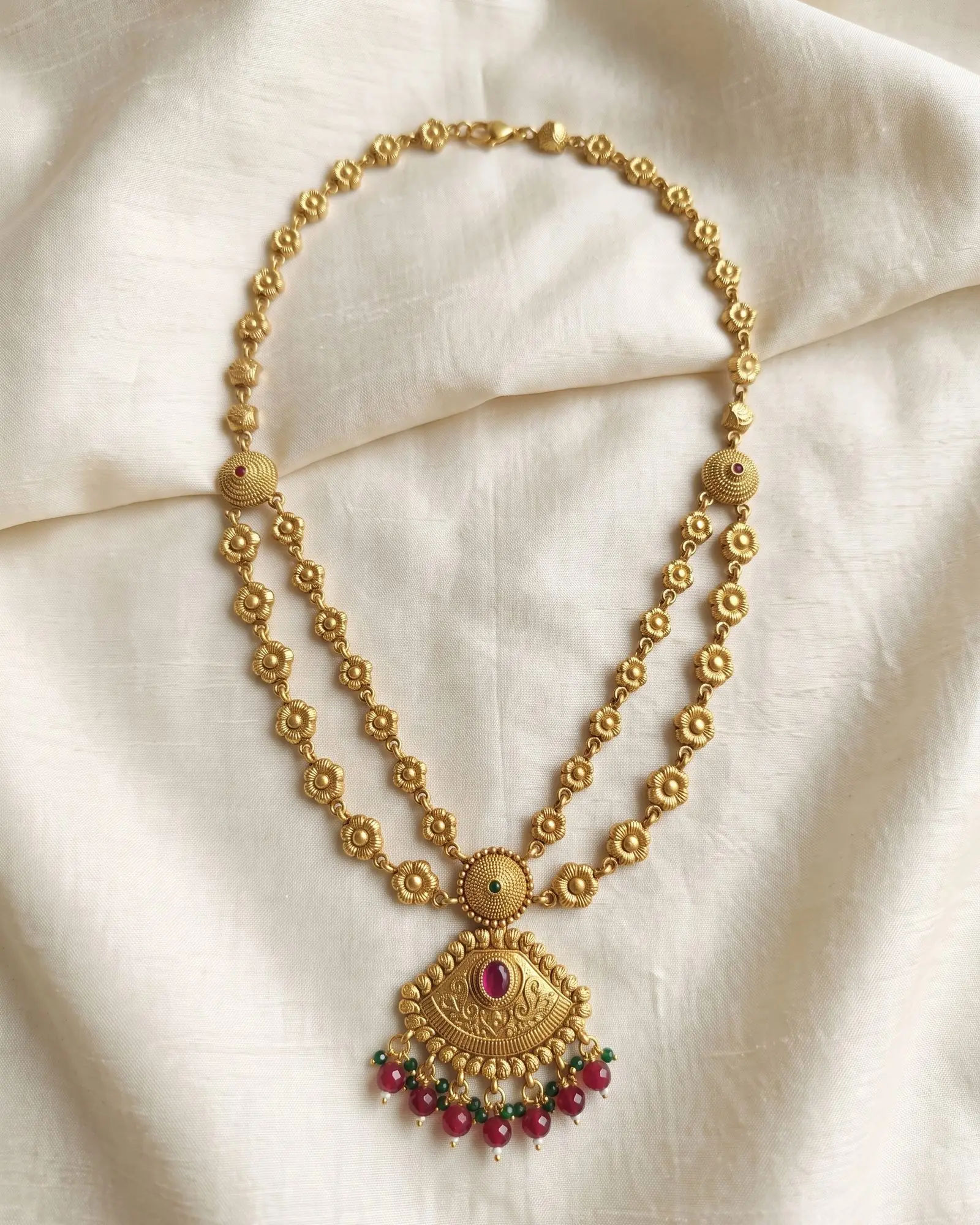 Antique Floral Motif Layered Necklace laid on white marble