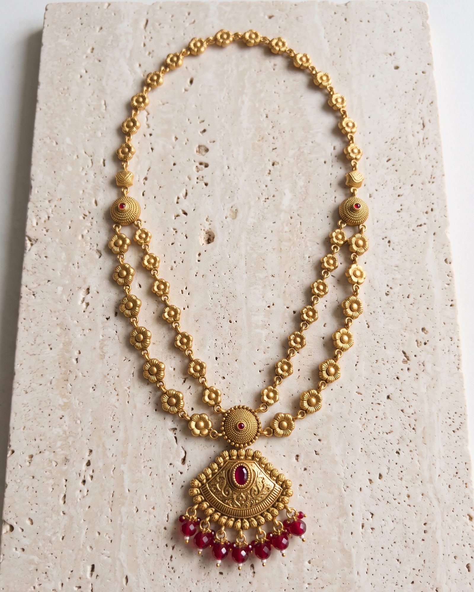 Antique Red Bead Drop Floral Layered Necklace laid on white marble