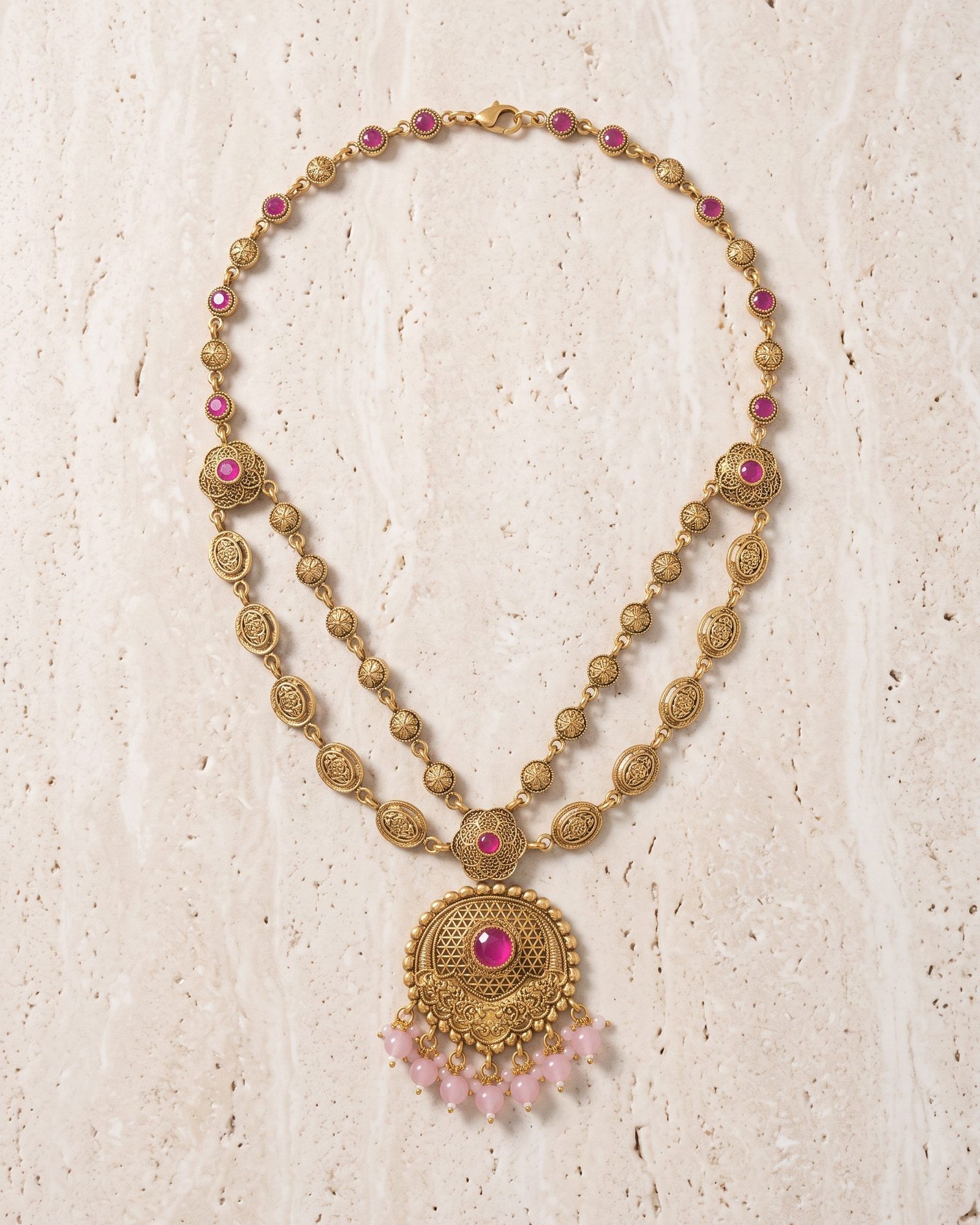 Antique Pink Stone Layered Necklace laid on white marble