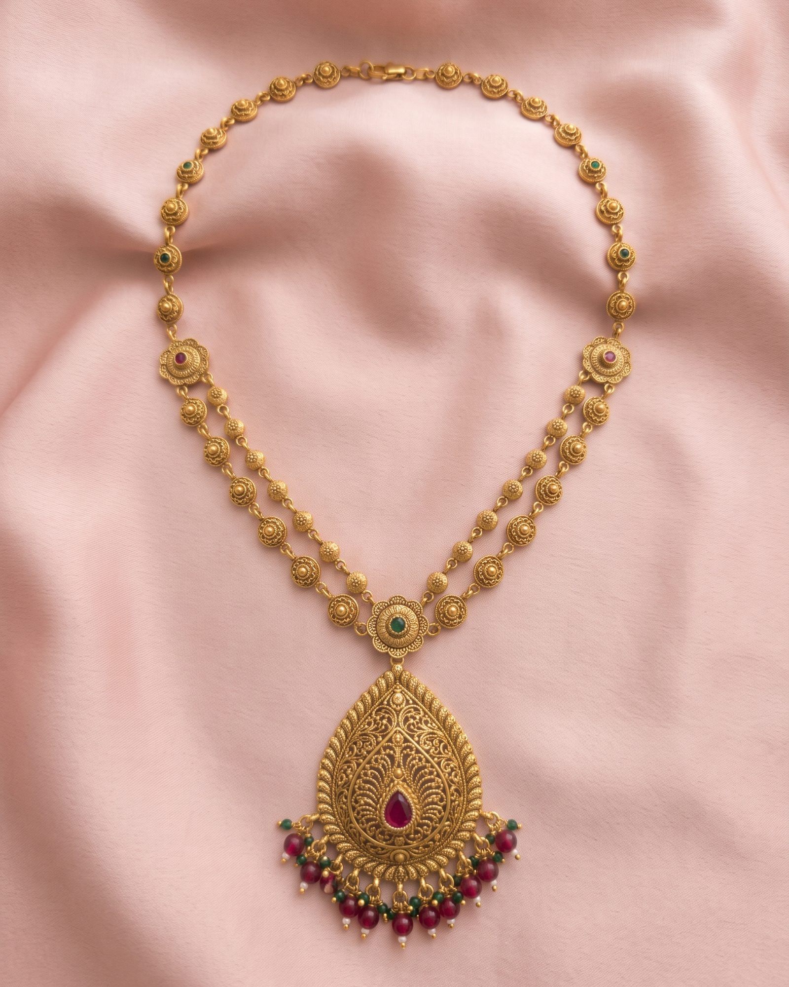 Antique Paisley Pendant Layered Necklace laid on white marble