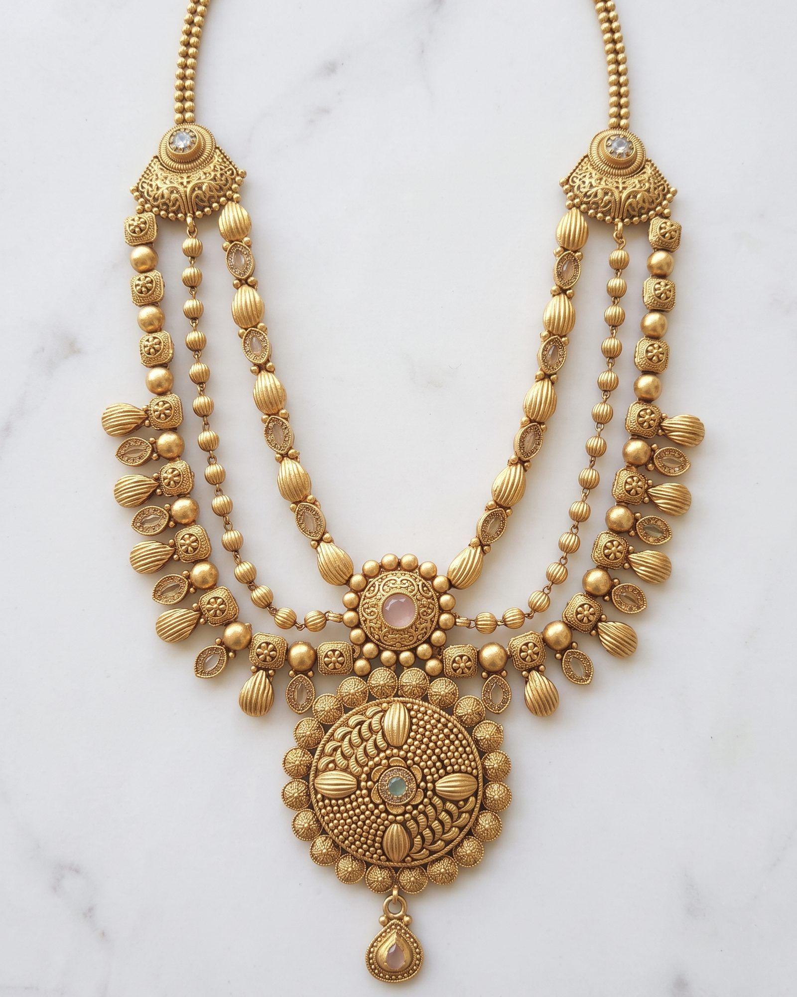 Antique Textured Medallion Layered Necklace laid on white marble